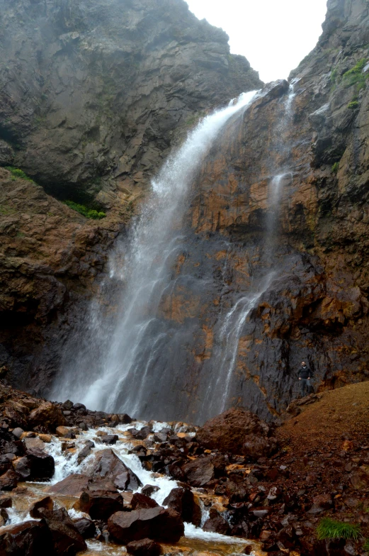 a group of rocks and water under a large waterfall