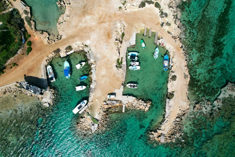 an aerial view of boats in the water near land