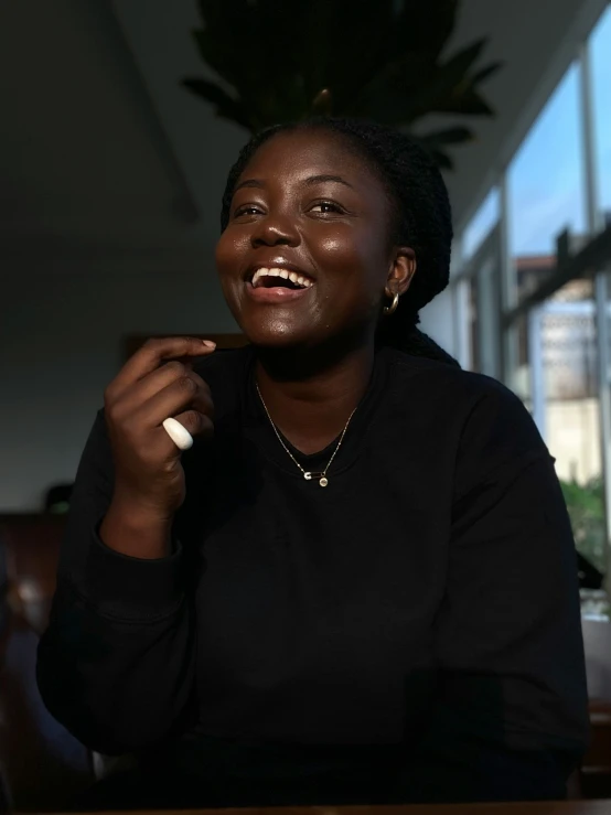 woman laughing with her finger near her lip