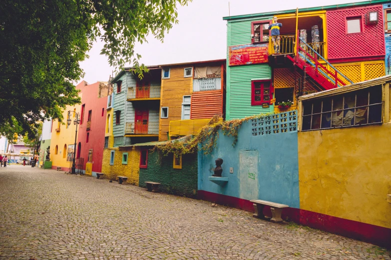 a group of multicolored houses near a road