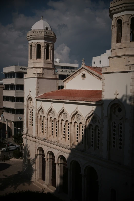 large stone church with tall steeples next to buildings