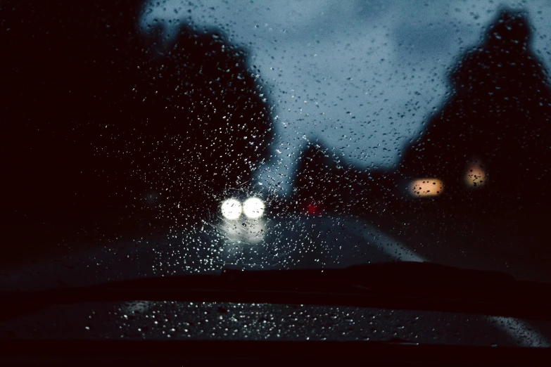 rain drops off the windshield at night in a rain storm