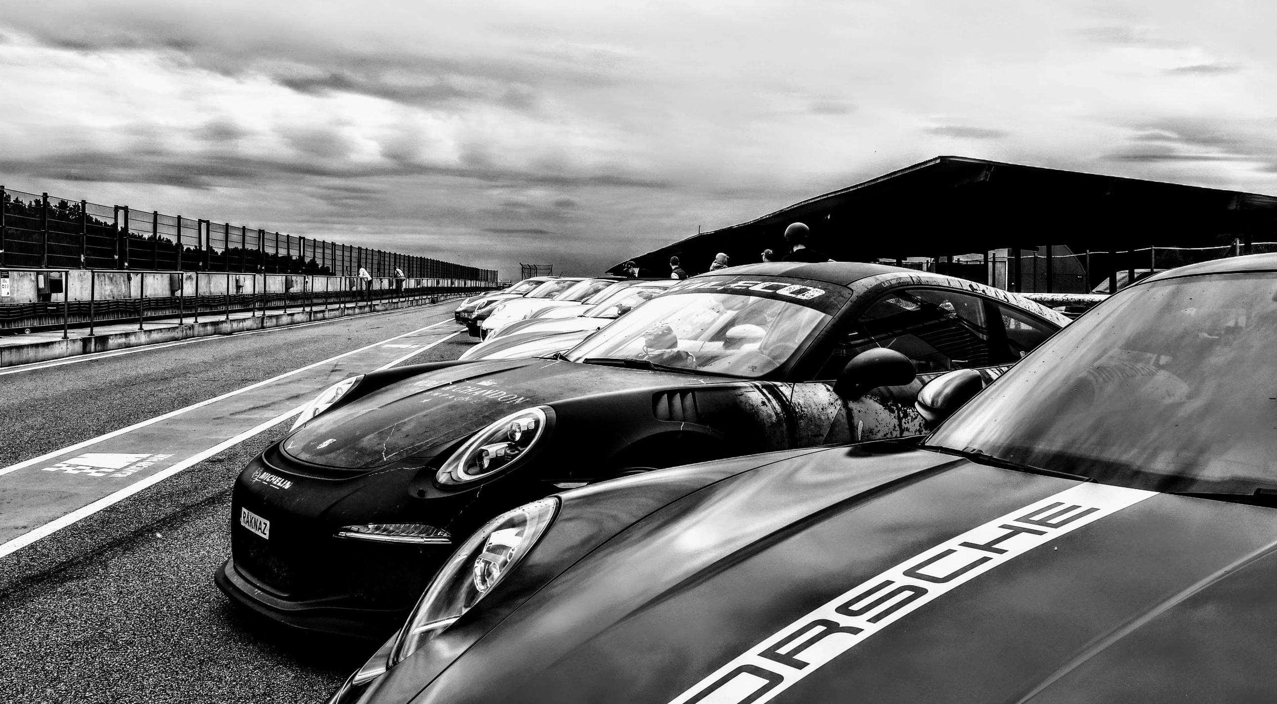 black and white po of three race cars