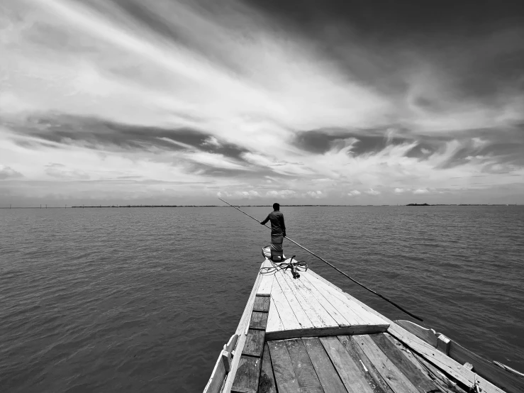 a man standing on a dock on top of a body of water