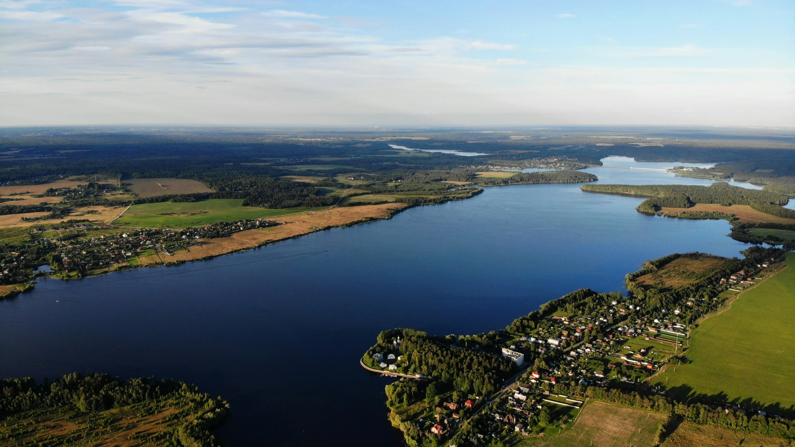 an aerial view of a lake surrounded by land and trees