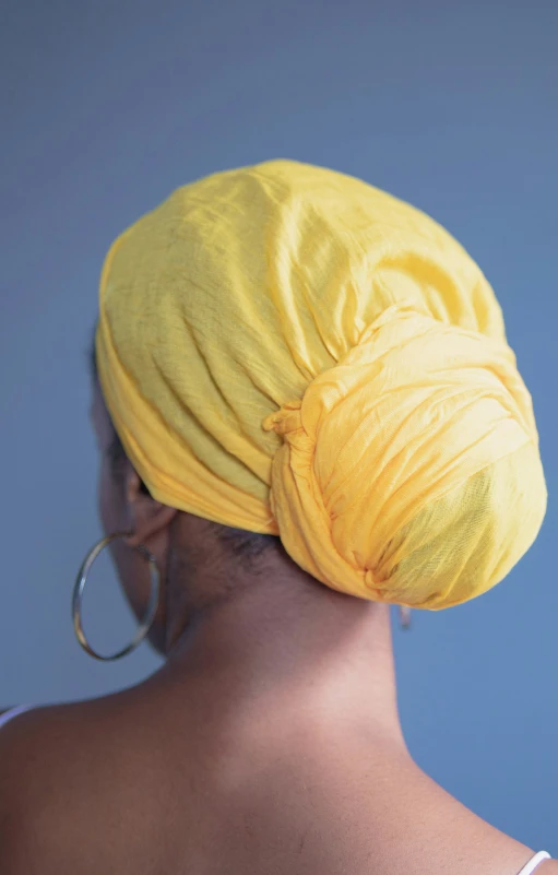 a woman with a yellow head wrap around her head