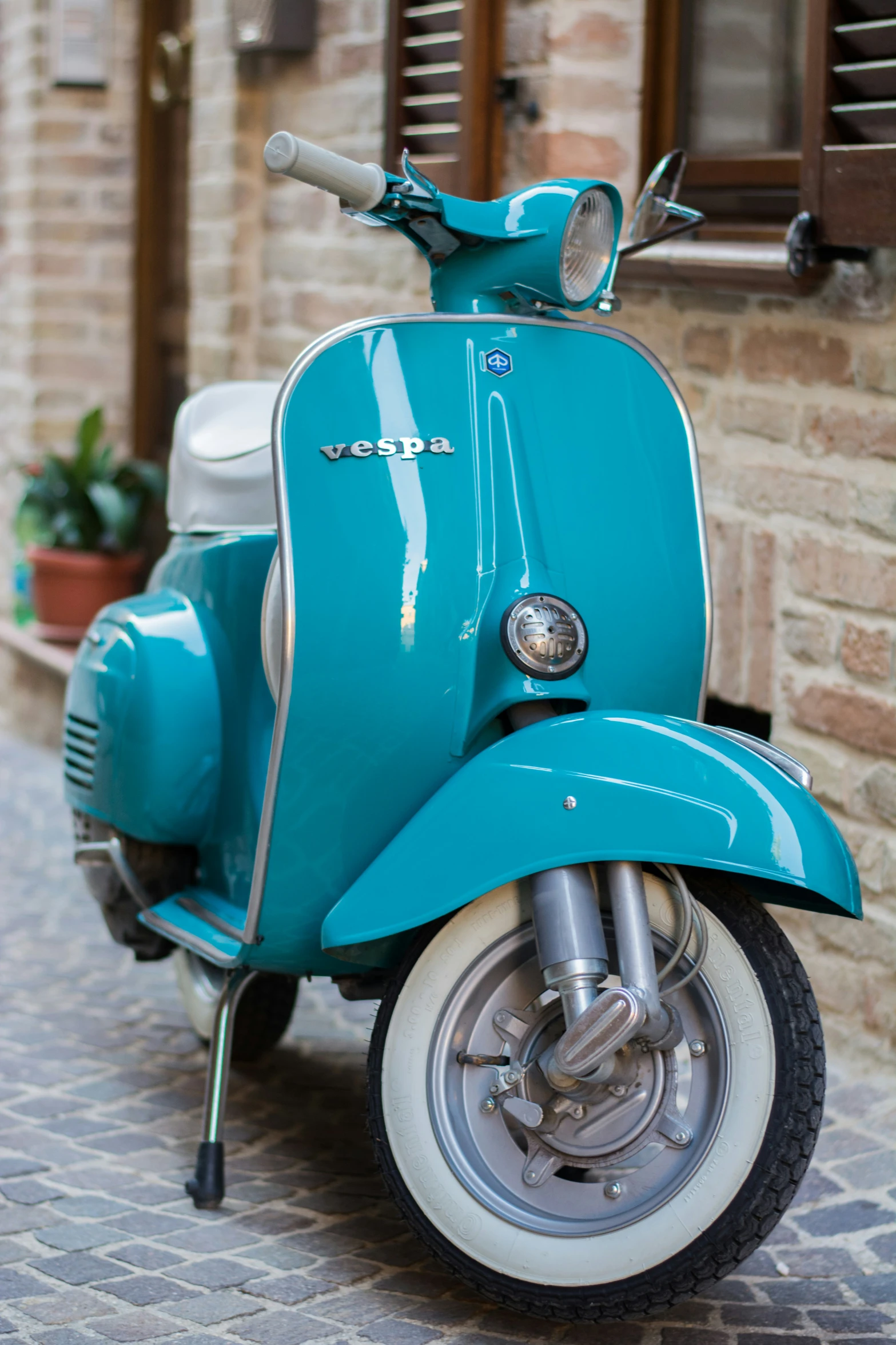 a moped that is parked next to some flowers