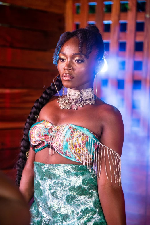 an african woman wearing a green costume with chains