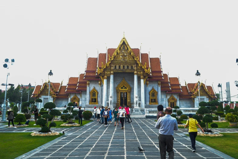 people walking around an elaborate white building