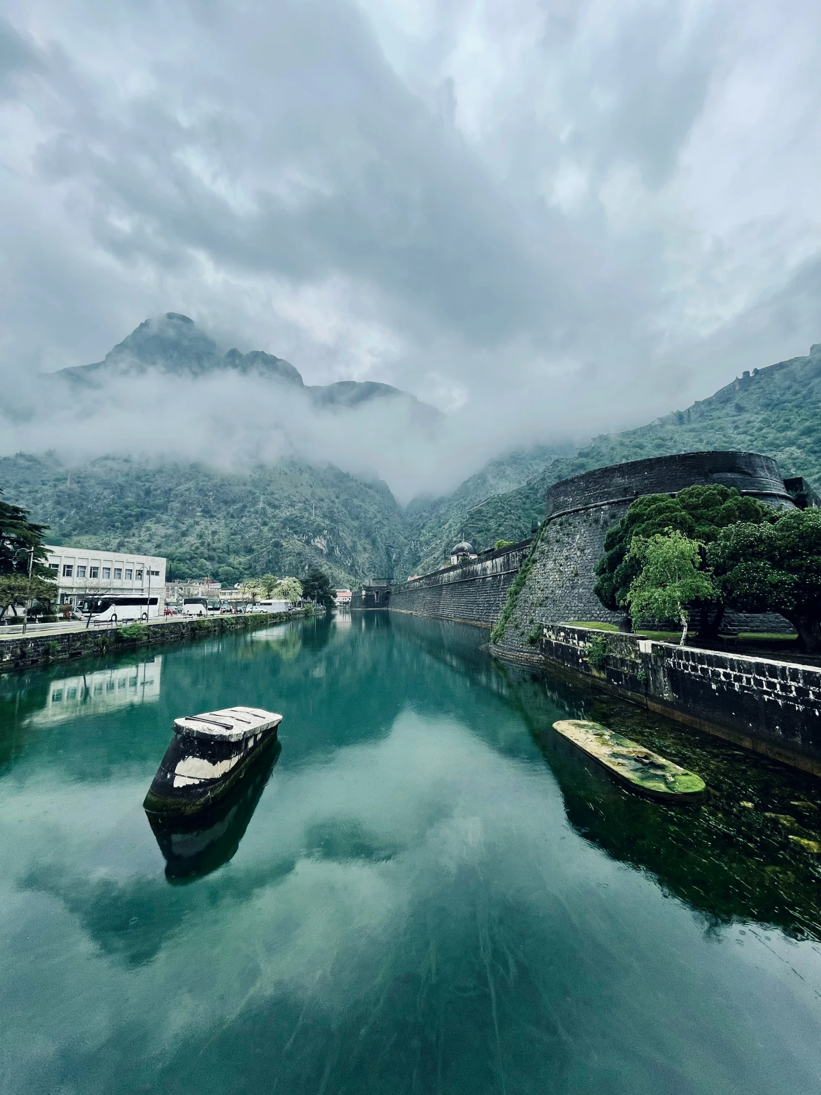 a lake in the middle of mountains near clouds