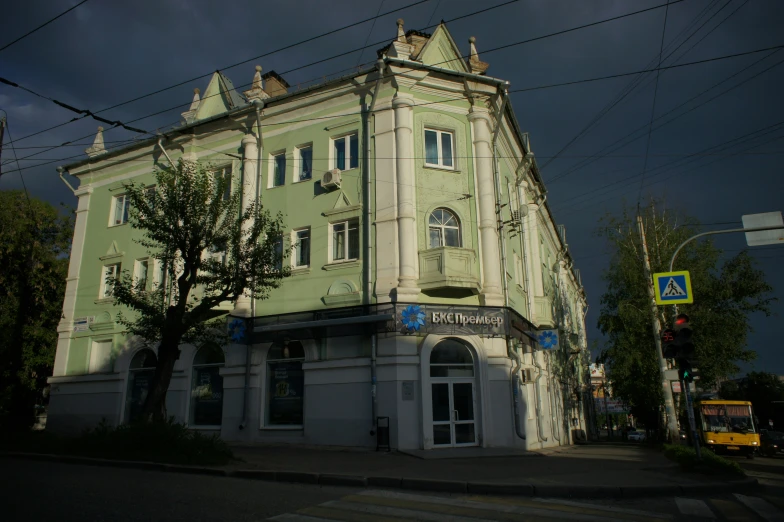 an old green and white building on the corner