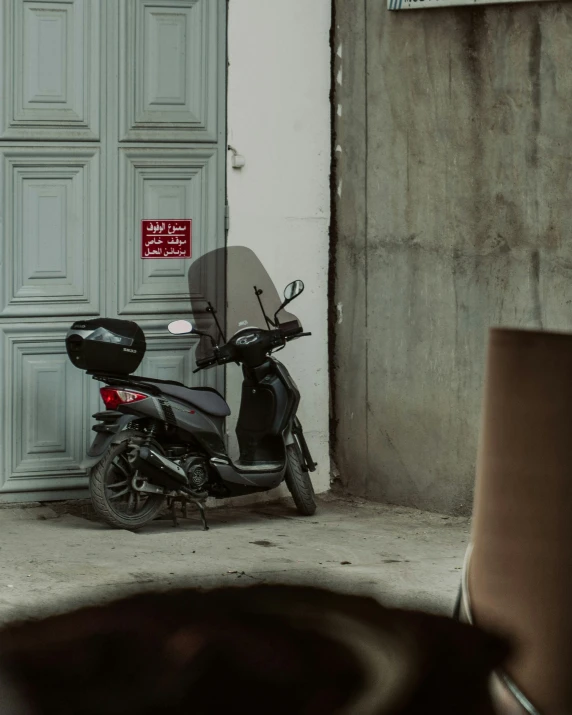 there is a motorbike with it's seat down parked by a building