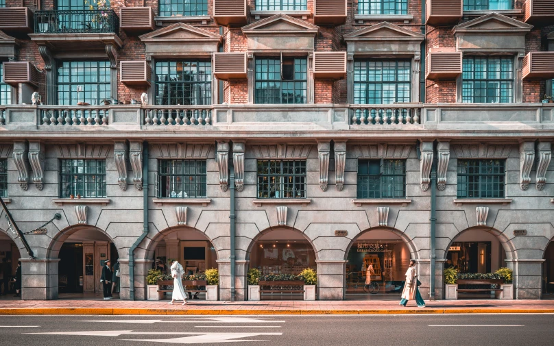 a woman crossing the street in front of a tall building