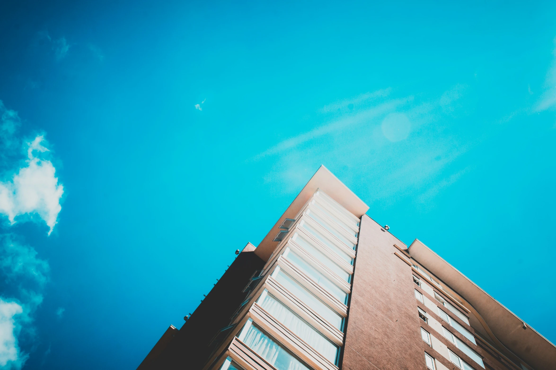 a tall building that is next to a cloud filled sky