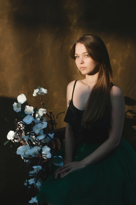 a beautiful young woman standing next to a bunch of white flowers