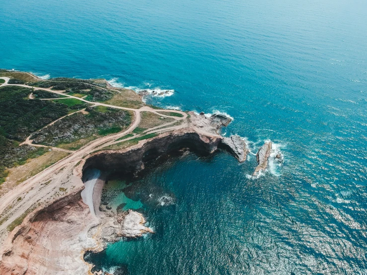 an aerial view of the ocean with white cliffs