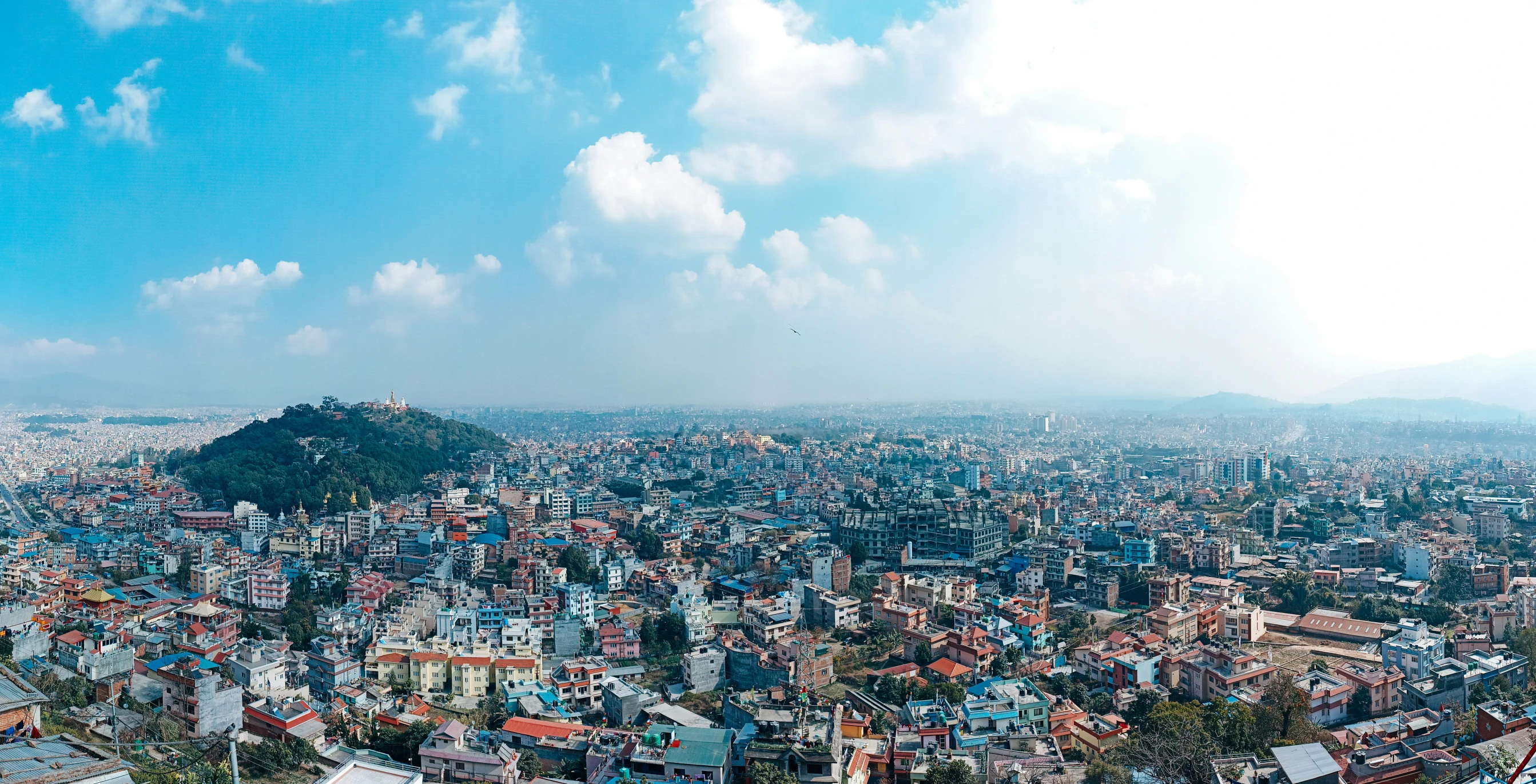 a city in a mountain valley with blue and white houses