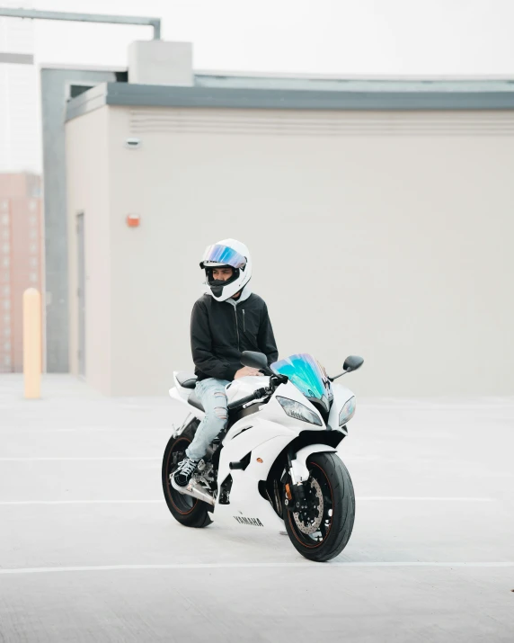 a man sitting on a white motorcycle with blue hair