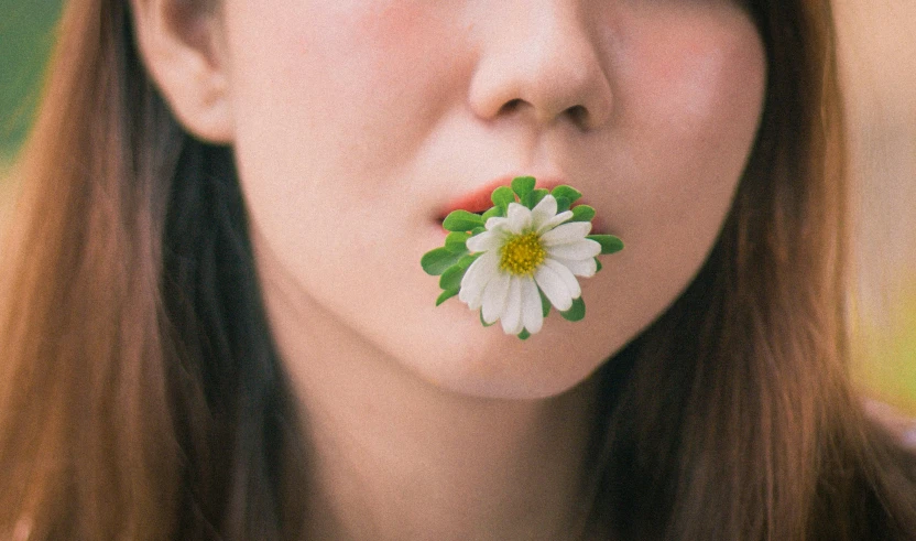 a woman holding a flower on her nose