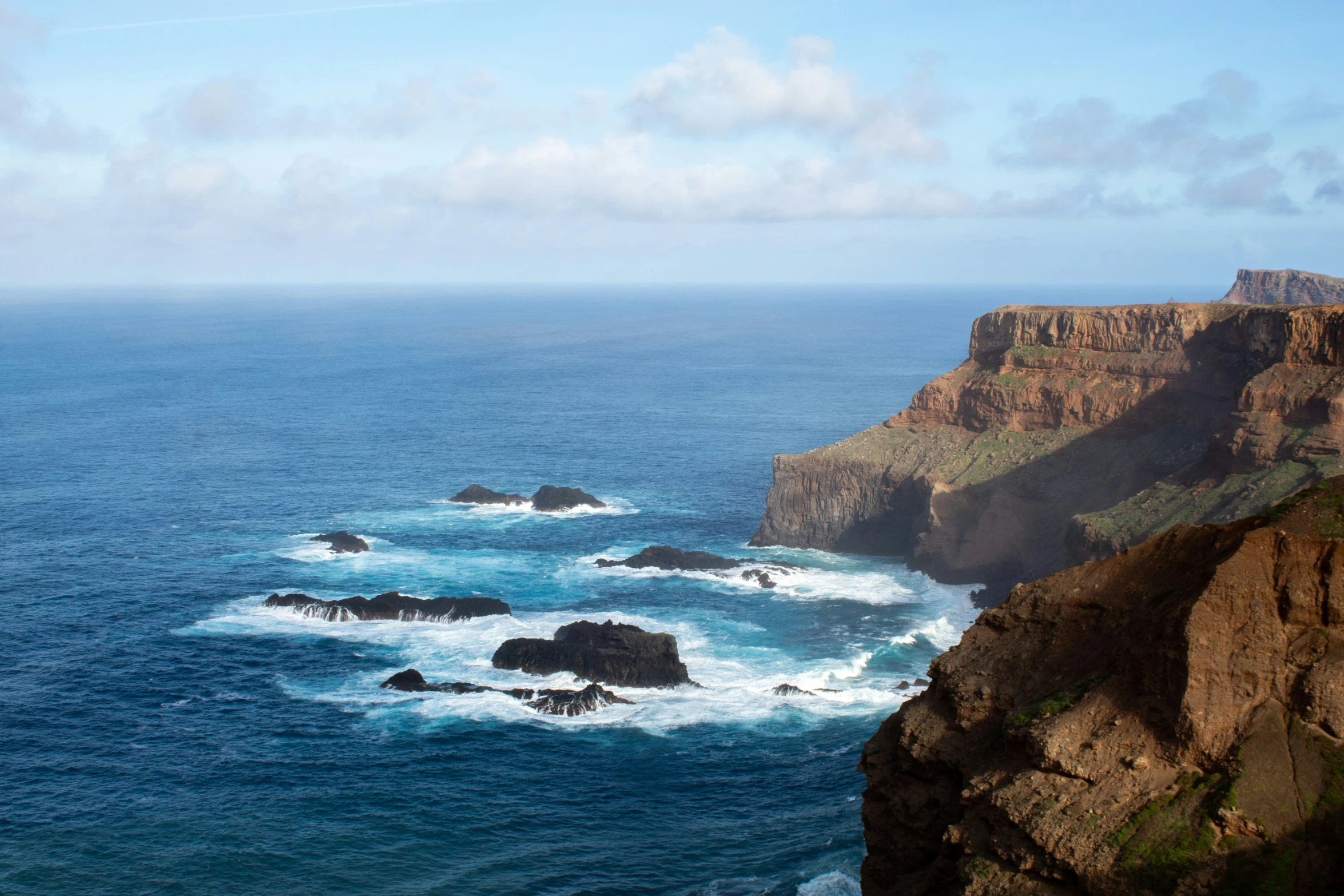 the ocean next to a cliff with lots of water