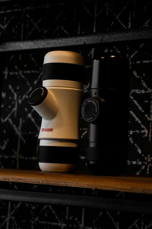 a coffee grinder and two cups sit on a shelf