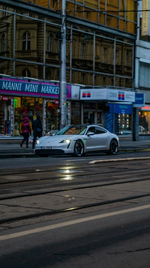 a white car on the road near buildings