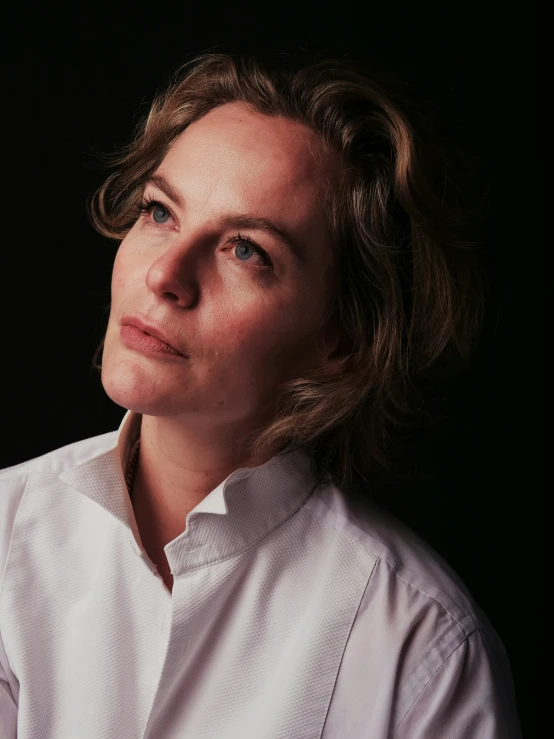 a close up of a woman wearing a white shirt