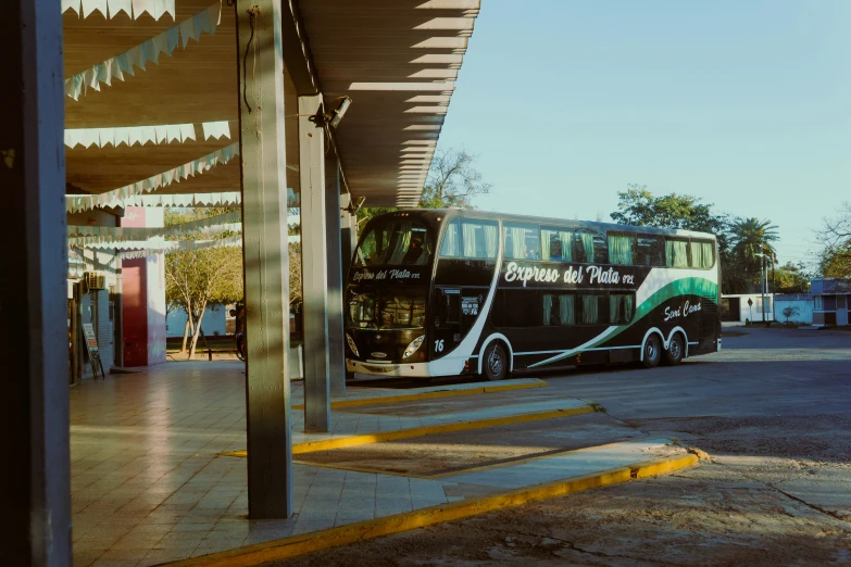 a bus parked in the front yard of a covered station