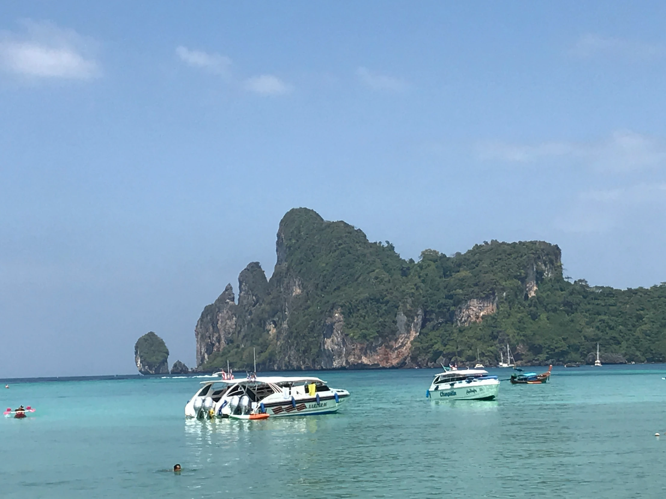 several small boats float in a clear ocean