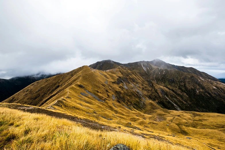 the mountains are covered in clouds and grass