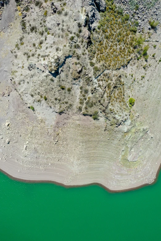 a clear green body of water surrounded by land and grass