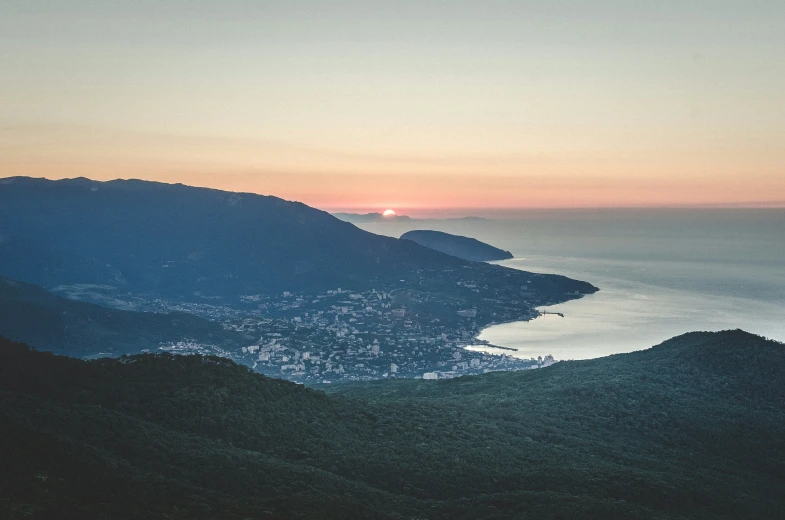 sunset over water in the distance from top of mountains