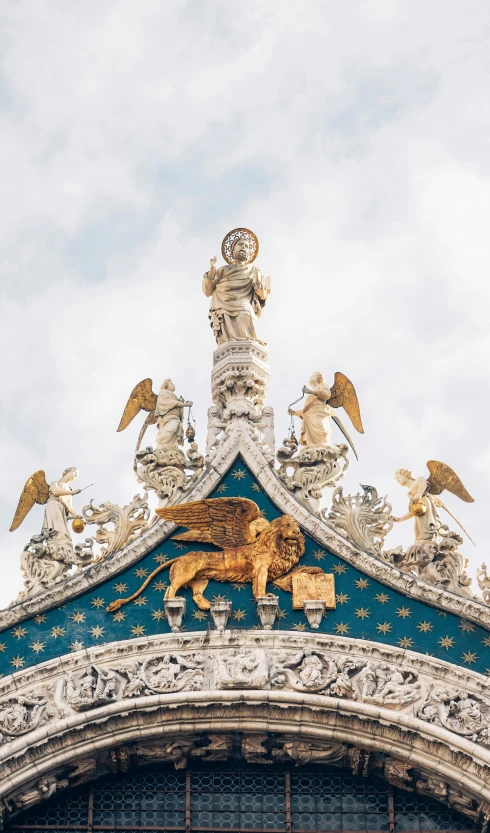 a tower with statues on top that is next to buildings