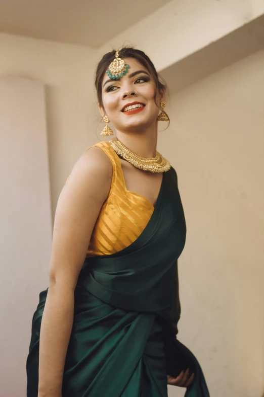 a woman is dressed in an indian traditional sari and smiling