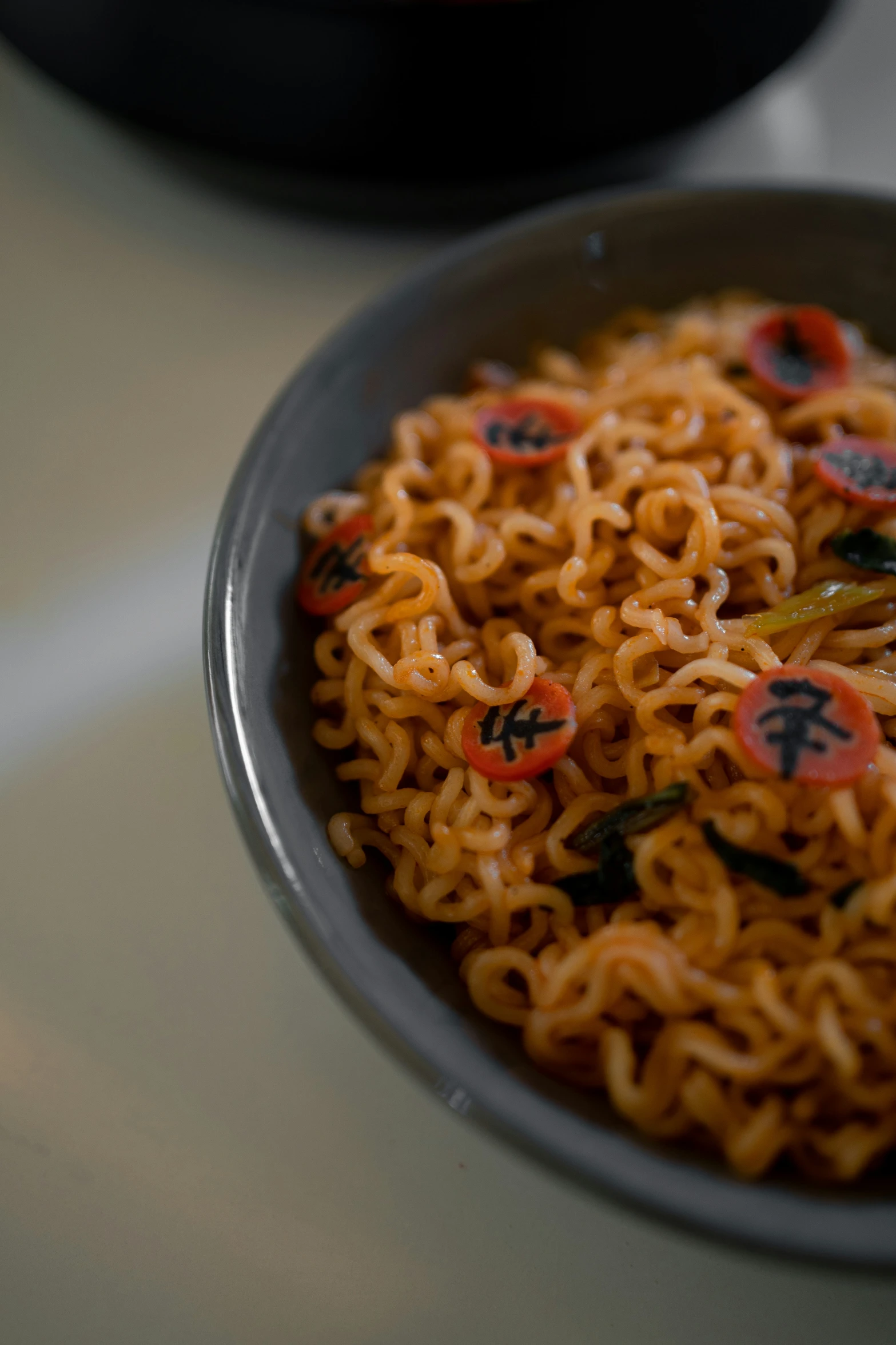 a plate of noodles with chopsticks, sauce and a pot of  water