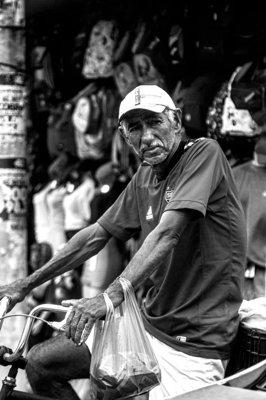 a black and white po of a man with a hat on riding a bike