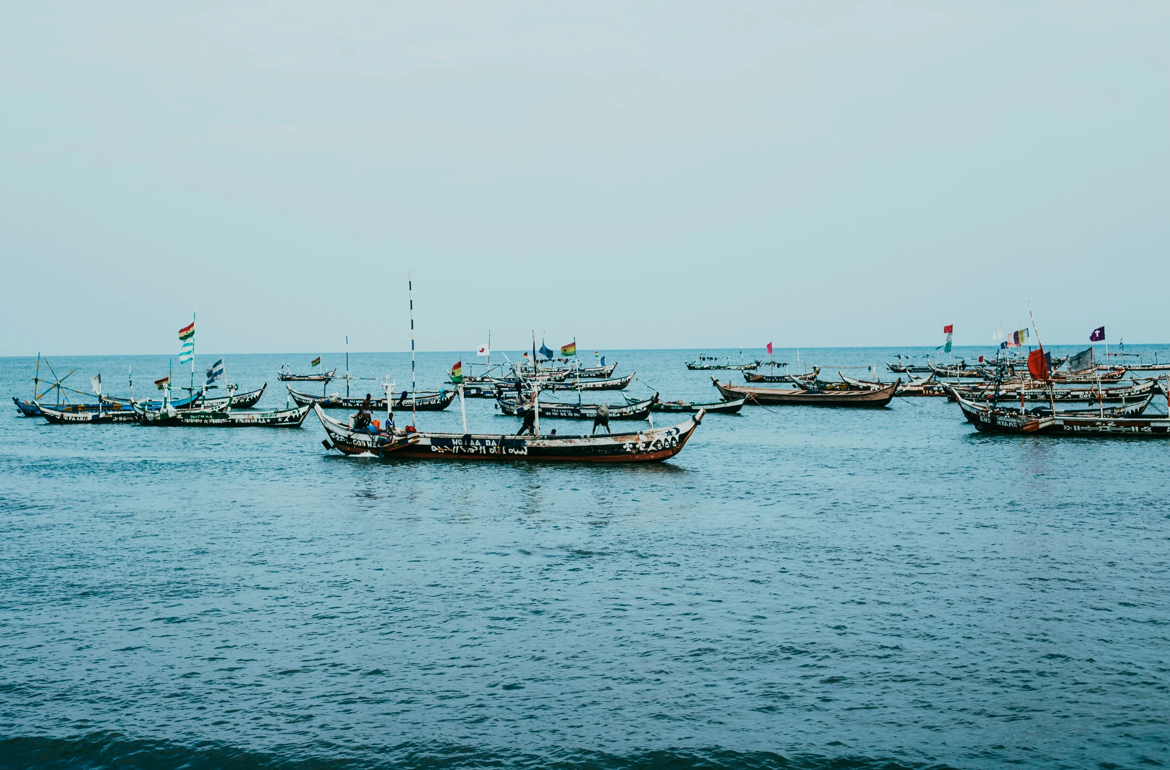 a number of small boats floating in the ocean