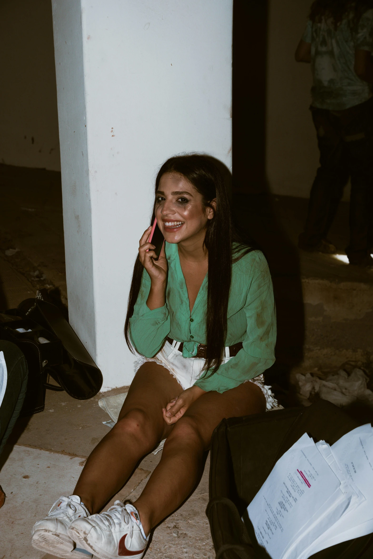 a woman in a green top sitting on a floor