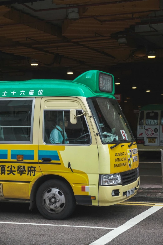 a yellow bus parked in a lot next to a building