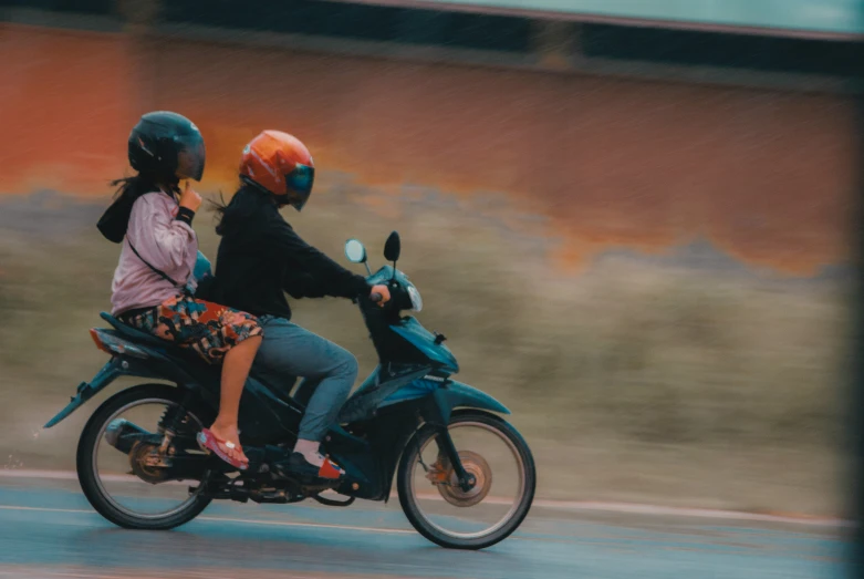 people on a motorcycle driving down the road