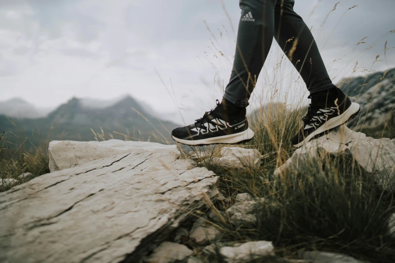 feet are standing on top of an alpine mountain