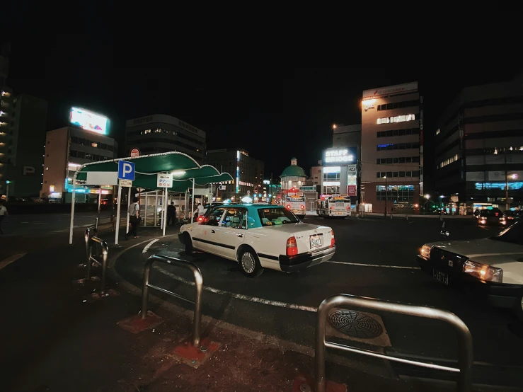 a very pretty car in a busy city at night