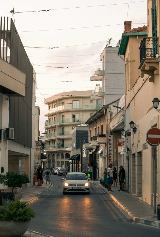 a car going down a street that is lined with buildings