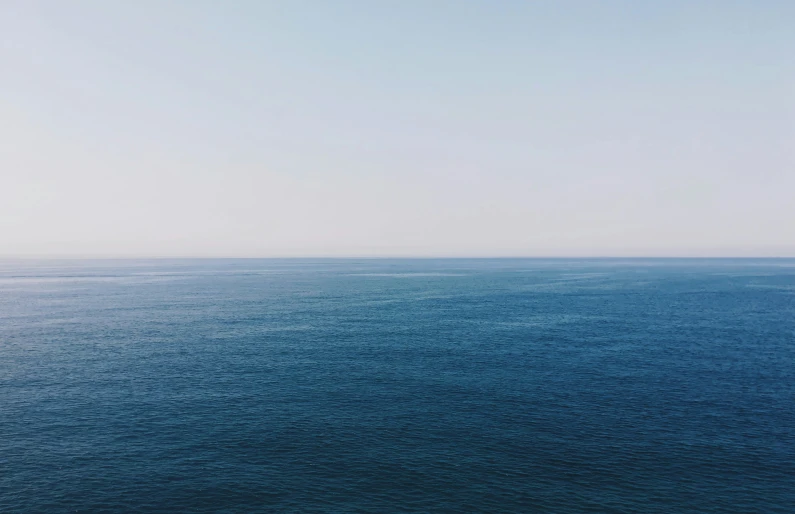 a body of water under a cloudy blue sky