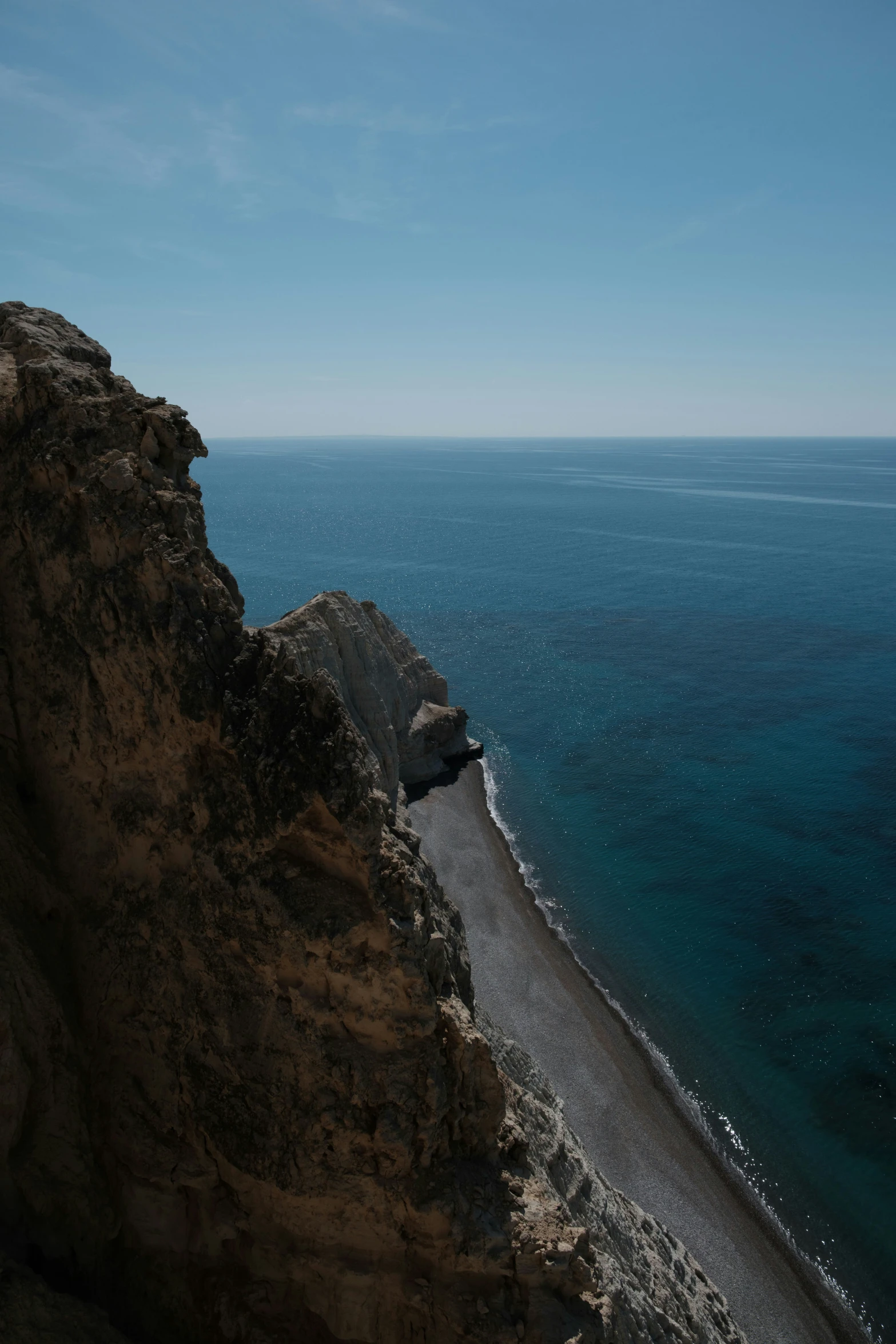 a rocky cliff is next to the ocean