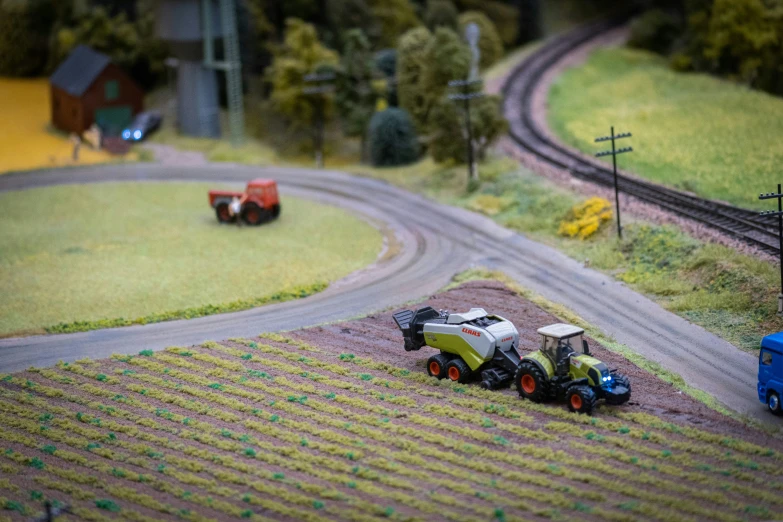 two toy tractors are parked on a farm track