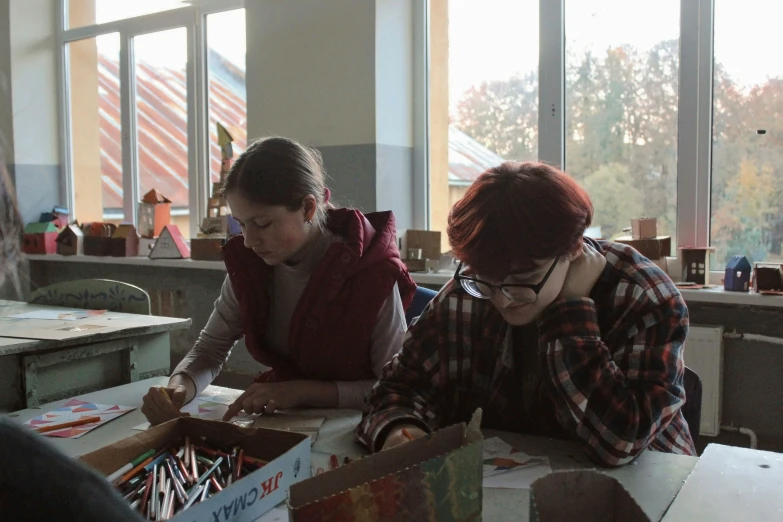 people sitting at a table playing with some cardboard