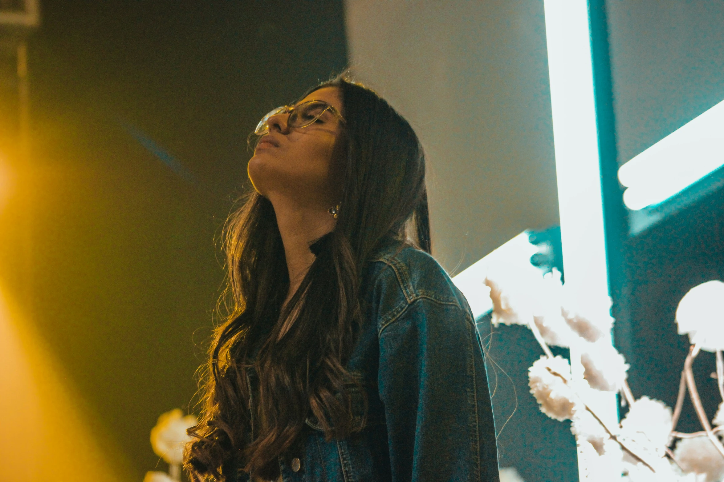 a girl looking up at soing with a light on behind her