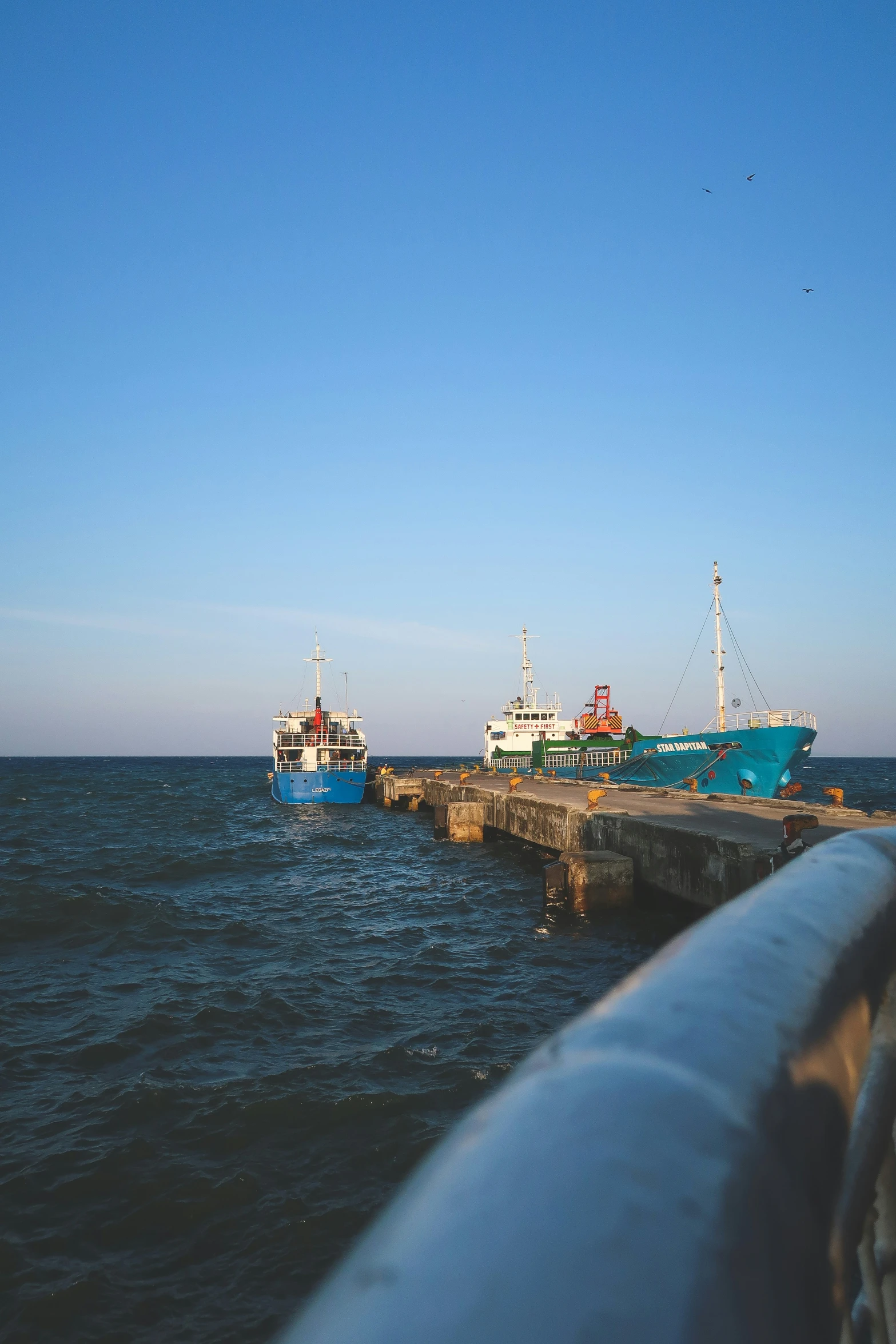 a blue and white ship docked on the side of a pier