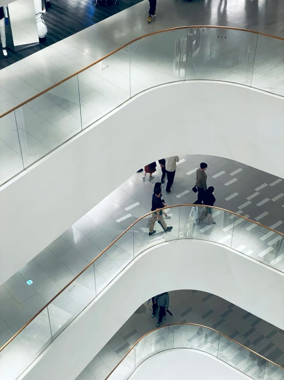 three men wearing coats are moving down a stairway